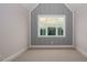 Cozy bedroom with a statement wall, plush carpet, and a large window offering serene views at 70 Water Willow Ln, Zebulon, NC 27597