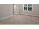 Light-filled bedroom offers carpet, a window overlooking outdoor greenery, and a door leading to a closet at 70 Water Willow Ln, Zebulon, NC 27597