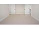 Neutral bedroom showcasing two doors, carpet flooring, and clean lines for a serene ambiance at 70 Water Willow Ln, Zebulon, NC 27597