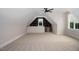 Large bonus room with carpet, dormer window, modern ceiling fan and convenient built-in desk area at 70 Water Willow Ln, Zebulon, NC 27597