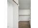 A walk-in closet with custom shelving, hanging rods, and hardwood flooring at 70 Water Willow Ln, Zebulon, NC 27597
