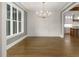 Open dining room with wainscoting, hardwood floors, and views of the kitchen at 70 Water Willow Ln, Zebulon, NC 27597