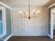 Stylish dining room with paneled accent wall, modern chandelier, and natural light at 70 Water Willow Ln, Zebulon, NC 27597