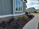 Charming exterior with gray siding, brick foundation, and landscaped front yard at 70 Water Willow Ln, Zebulon, NC 27597