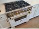 Close-up of a white and stainless Zline kitchen range with brass colored knobs at 70 Water Willow Ln, Zebulon, NC 27597