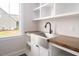 Bright laundry room with stainless steel sink, dark wood counters and ample storage cabinets at 70 Water Willow Ln, Zebulon, NC 27597