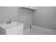 Clean laundry room featuring a utility sink and marble-look flooring at 70 Water Willow Ln, Zebulon, NC 27597