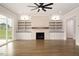 Spacious living room with built-in shelves, fireplace, ceiling fan, and sliding glass doors at 70 Water Willow Ln, Zebulon, NC 27597