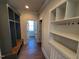 Mudroom with built-in cubbies, shelving, coat hooks, and wood floors at 70 Water Willow Ln, Zebulon, NC 27597