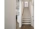 Interior staircase with white risers and wooden treads, leading to the upper level at 70 Water Willow Ln, Zebulon, NC 27597