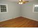 The bedroom features hardwood floors and two windows for natural lighting at 1005 E C St, Butner, NC 27509