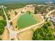 Aerial view of the property pond and lush surrounding greenery with neighborhood homes nearby at 27 Asti Ct, Clayton, NC 27527