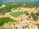 Aerial shot of the property with a large pond, equestrian facilities, and surrounding greenery offering a peaceful retreat at 27 Asti Ct, Clayton, NC 27527