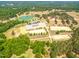Expansive aerial view of the estate, showcasing multiple arenas, stables, a pond, and lush green pastures at 27 Asti Ct, Clayton, NC 27527