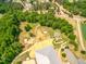 Overhead perspective of equestrian property with paddocks, training areas, and tree lined landscape, offering privacy at 27 Asti Ct, Clayton, NC 27527
