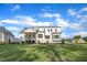 Expansive backyard view highlighting the home's screened porch and ample lawn space under a blue sky at 27 Asti Ct, Clayton, NC 27527