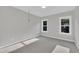 The bedroom has gray carpet, light gray walls and two windows that let in natural light at 27 Asti Ct, Clayton, NC 27527