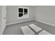 Bedroom with light gray walls, a window with natural lighting, gray carpet, and a door at 27 Asti Ct, Clayton, NC 27527