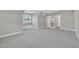 Large, carpeted bonus room featuring a window seat and access through stylish glass paneled doors at 27 Asti Ct, Clayton, NC 27527