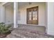 Welcoming front porch featuring elegant double doors, brick steps, and white columns at 27 Asti Ct, Clayton, NC 27527