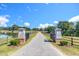 Inviting gated entrance leads to a private driveway lined with a fence, showcasing the property's serene setting at 27 Asti Ct, Clayton, NC 27527