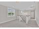Well-lit hallway with carpet floors and stairs leading down, enhanced by a decorative hanging light fixture at 27 Asti Ct, Clayton, NC 27527