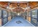 Interior view of horse stables featuring wooden stalls, metal gates and a well-lit, clean alleyway at 27 Asti Ct, Clayton, NC 27527