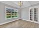 Cozy living room with hardwood floors, a large window, and French doors at 27 Asti Ct, Clayton, NC 27527