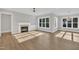 Bright living room with fireplace, built-ins, large windows, and wood floors at 27 Asti Ct, Clayton, NC 27527