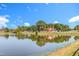 Picturesque pond reflecting the charming home with a red roof, surrounded by lush trees and greenery at 27 Asti Ct, Clayton, NC 27527