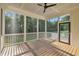 Inviting screened porch featuring wood flooring, a ceiling fan, and views of the lush backyard at 27 Asti Ct, Clayton, NC 27527