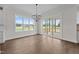 Sunlit dining area with hardwood floors, a modern chandelier, and sliding glass doors leading to an outdoor deck at 5124 Grist Stone Way, Youngsville, NC 27596