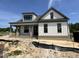 New construction home featuring vertical siding, brick foundation, covered porch, and black window frames at 5124 Grist Stone Way, Youngsville, NC 27596