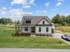 Charming two-story home with manicured lawn, covered porch, and a long driveway leading to the side garage at 5124 Grist Stone Way, Youngsville, NC 27596
