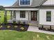 Close-up of the home's entrance, featuring a brick-accented porch and a beautiful wood and glass front door at 5124 Grist Stone Way, Youngsville, NC 27596