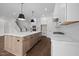 Contemporary kitchen with a central island, sleek appliances, and hardwood floors, and a staircase nearby at 5124 Grist Stone Way, Youngsville, NC 27596