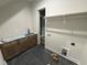 Spacious laundry room with dark tile, wood cabinets and hanging rod at 5124 Grist Stone Way, Youngsville, NC 27596