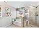 Bright bathroom featuring a soaking tub and glass-enclosed shower with tiled walls at 1024 Dillon Lake Dr, Knightdale, NC 27545