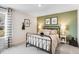 Cozy bedroom with a black metal bed frame, green accent wall, and natural light at 1024 Dillon Lake Dr, Knightdale, NC 27545