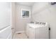 Neat laundry room with white appliances and shelving, illuminated by a bright window at 1024 Jarrett Bay Rd, Willow Springs, NC 27592