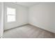 Minimalist bedroom featuring plush carpeting, crisp white walls, and a bright window at 1425 Patchings Ln, Knightdale, NC 27545