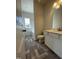 Bright bathroom featuring a white vanity, toilet, and a window over a tub with gray tile floors at 180 Deodora Ln, Cameron, NC 28326