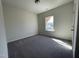 A vacant bedroom with plush carpeting and a bright window creates a cozy and adaptable space at 180 Deodora Ln, Cameron, NC 28326