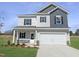 Charming two-story home featuring a two-car garage, inviting front porch, and modern siding design at 180 Deodora Ln, Cameron, NC 28326