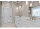 Bathroom with a double sink vanity with a quartz countertop, stylish light fixtures, and a walk-in shower at 418 S Cross St, Youngsville, NC 27596