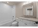 Well-lit bathroom featuring a shower-tub combination, white subway tile, and vanity at 418 S Cross St, Youngsville, NC 27596