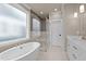 Luxurious bathroom showcases a freestanding tub, glass-enclosed shower, and herringbone-patterned tile accent wall at 418 S Cross St, Youngsville, NC 27596