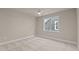 Comfortable bedroom features neutral carpet, a ceiling fan, and a window overlooking the exterior at 418 S Cross St, Youngsville, NC 27596