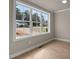 Bedroom with neutral walls, wood floors, white trim and large windows with street view at 418 S Cross St, Youngsville, NC 27596