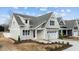 Charming two-story home featuring a classic white garage, complemented by lush landscaping at 418 S Cross St, Youngsville, NC 27596